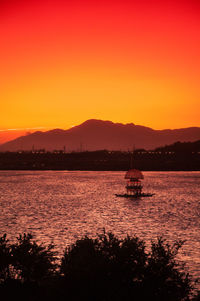 Scenic view of lake against dramatic sky during sunset