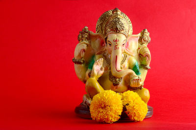 Buddha statue against red background