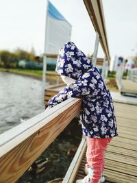 Rear view of woman in boat against river