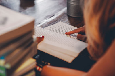Close-up of woman reading book on table