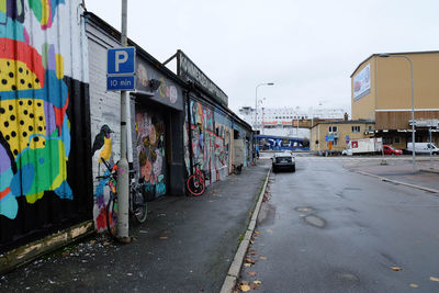 Car moving on road by graffiti buildings