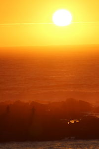 Scenic view of sea against orange sky