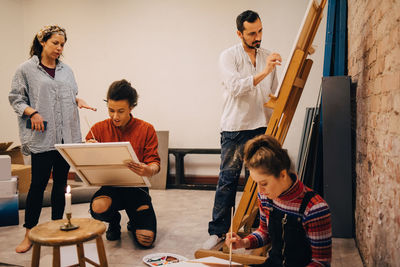 Instructor explaining male and female artists at art studio