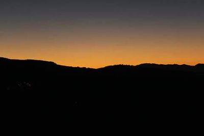 Scenic view of silhouette mountains against sky at sunset