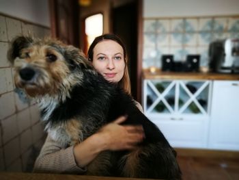 Portrait of man with dog sitting at home