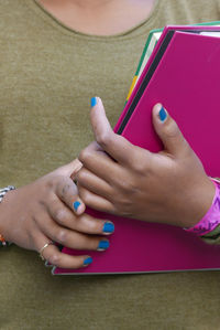 Midsection of woman holding pink file