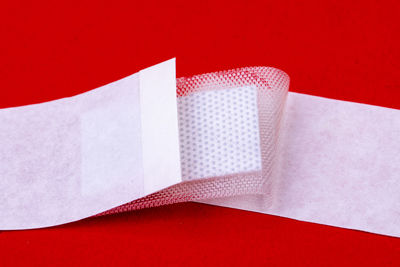 High angle view of white paper on table against red background