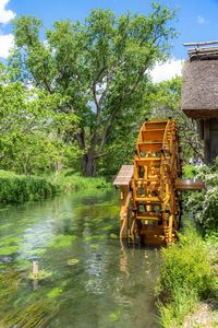 Built structure by river in forest against sky