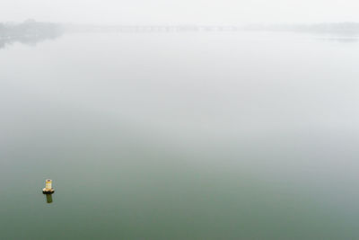 Water measurement gauge in lake during foggy weather