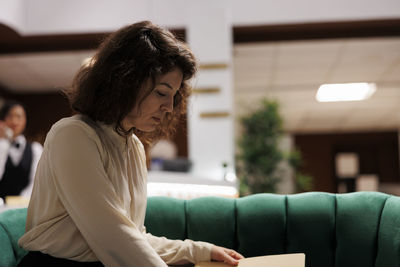 Side view of young woman using laptop while sitting at home