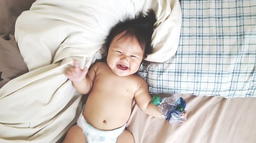 Cute shirtless baby on bed
