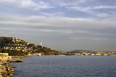 Buildings in city against cloudy sky