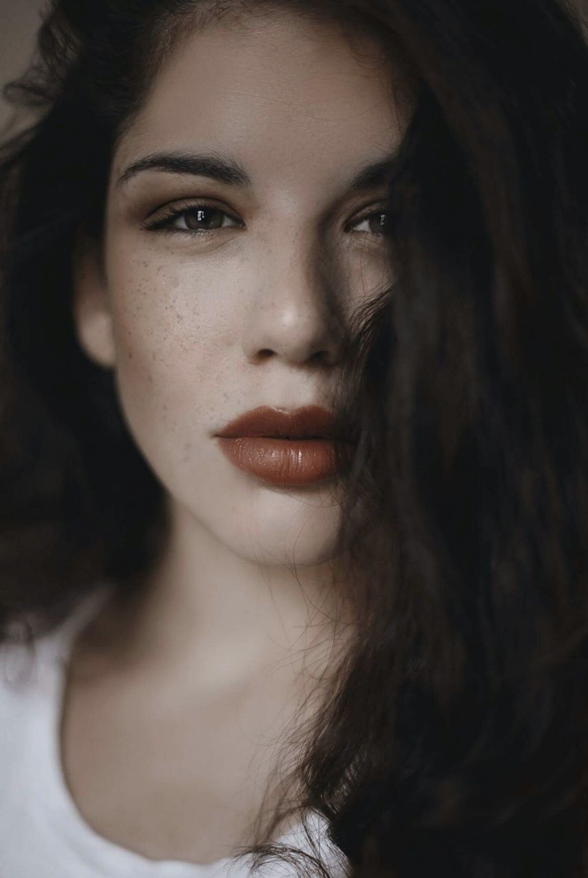 young adult, young women, headshot, lifestyles, person, long hair, beauty, leisure activity, close-up, indoors, human face, looking at camera, black hair, serious, focus on foreground, domestic life, eyelash