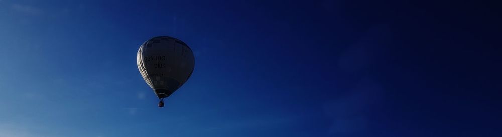 Low angle view of hot air balloon against clear blue sky