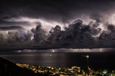 Scenic view of sea against storm clouds at night