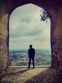 Rear view of man looking at sea against sky