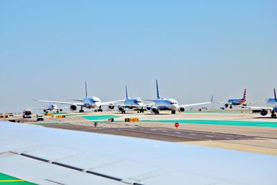 Airplane on airport runway against clear sky