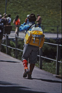 Rear view of men walking on road