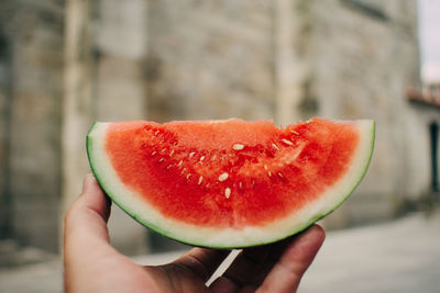 Cropped image of person holding watermelon slice