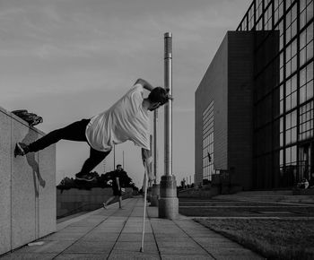 Man skateboarding on city against sky