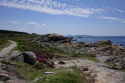 Rocks by sea against sky