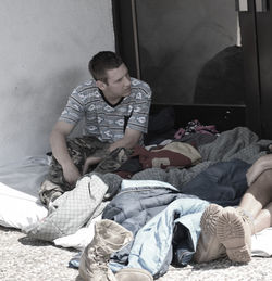 Young man sitting on bed at home