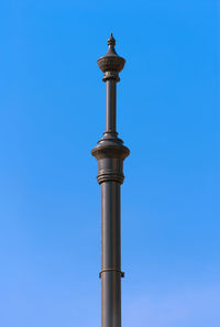 Low angle view of communications tower against blue sky