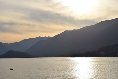 Scenic view of sea and mountains against sky during sunset