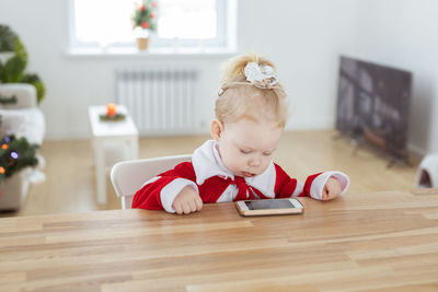 Portrait of cute baby girl sitting on table