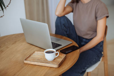 Young woman working remotely at home using a laptop