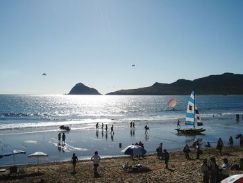 People at beach against sky