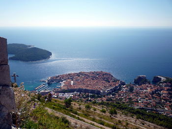 High angle view of cityscape by sea against sky