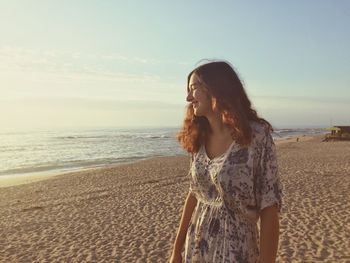 Happy woman standing on sand at beach