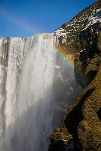 Scenic view of waterfall against sky