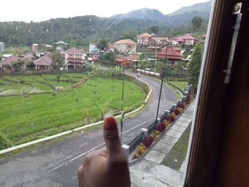 Cropped image of person on road by buildings in city