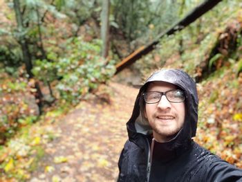 Portrait of happy man wearing mask against trees