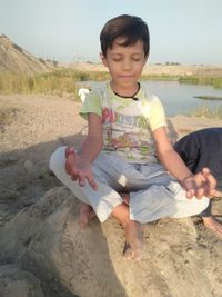 Full length of boy sitting on beach