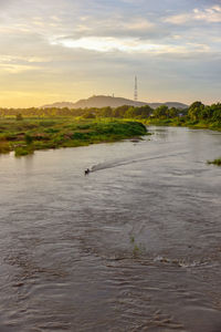 Scenic view of river against sky at sunset