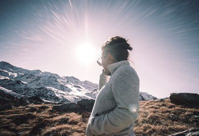 Side view of man standing on mountain during winter