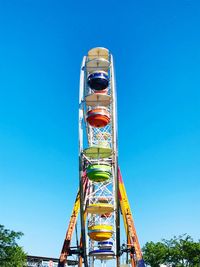 Low angle view of ferris wheel against clear blue sky