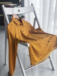 Close-up of yellow chair on table at home