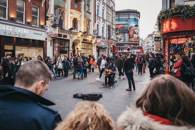 People on street against buildings in city