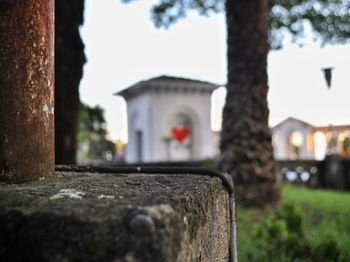 Close-up of cemetery by building against sky