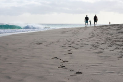 Rear view of man walking at beach