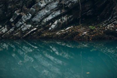 Close-up of rock formation reflecting in lake