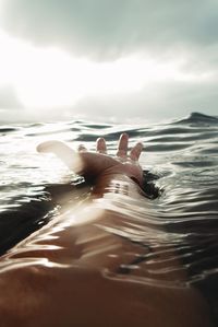 Woman swimming in sea against sky