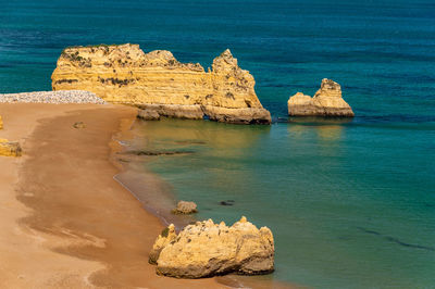 Scenic view of rocks on sea against sky