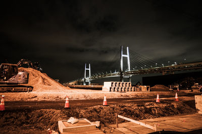 Illuminated bridge against sky at night