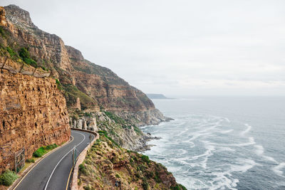 Scenic view of road by sea against sky