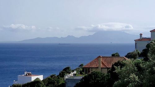 High angle view of buildings by sea against sky